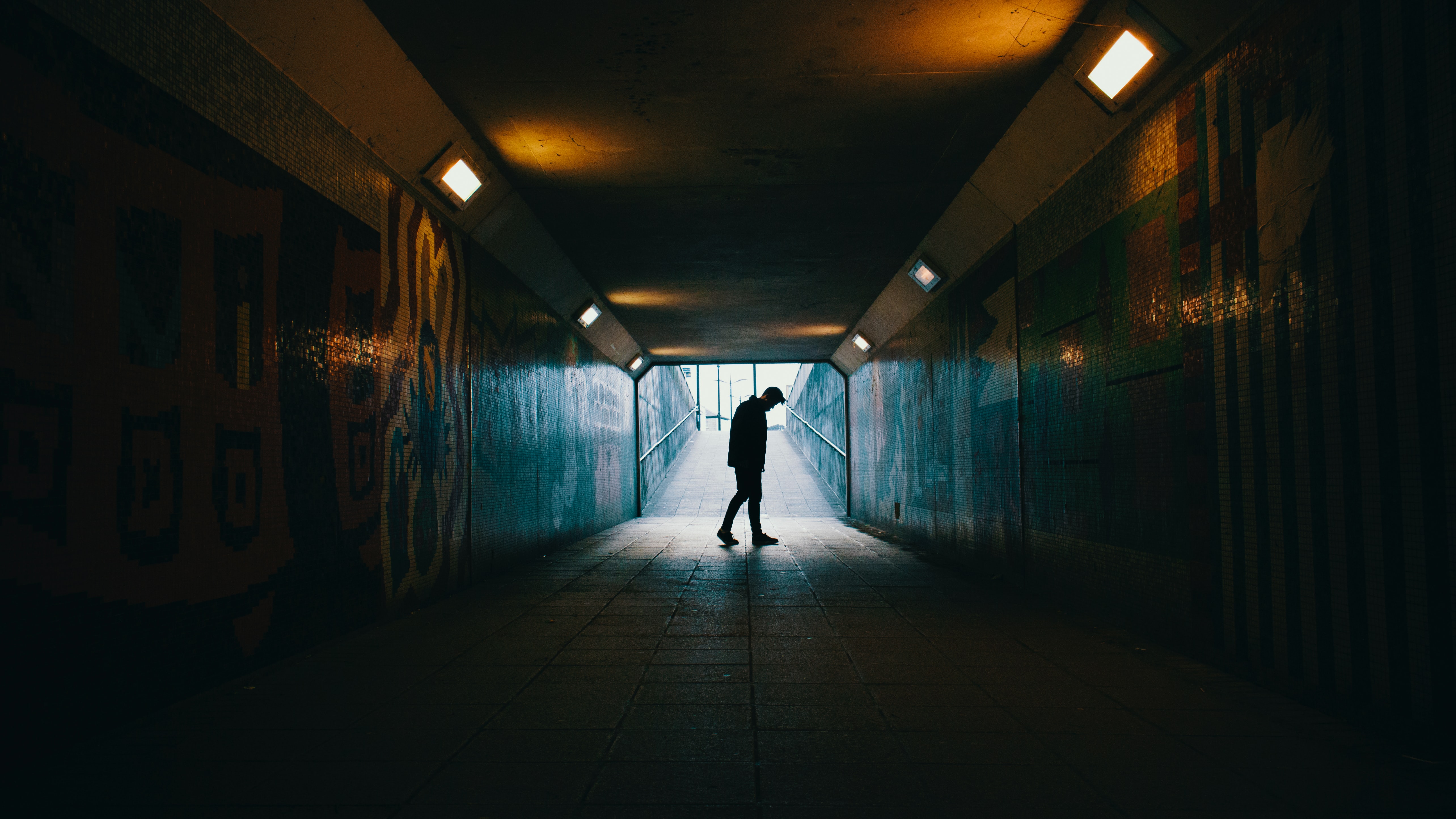 silhouette of man inside subway tunnel