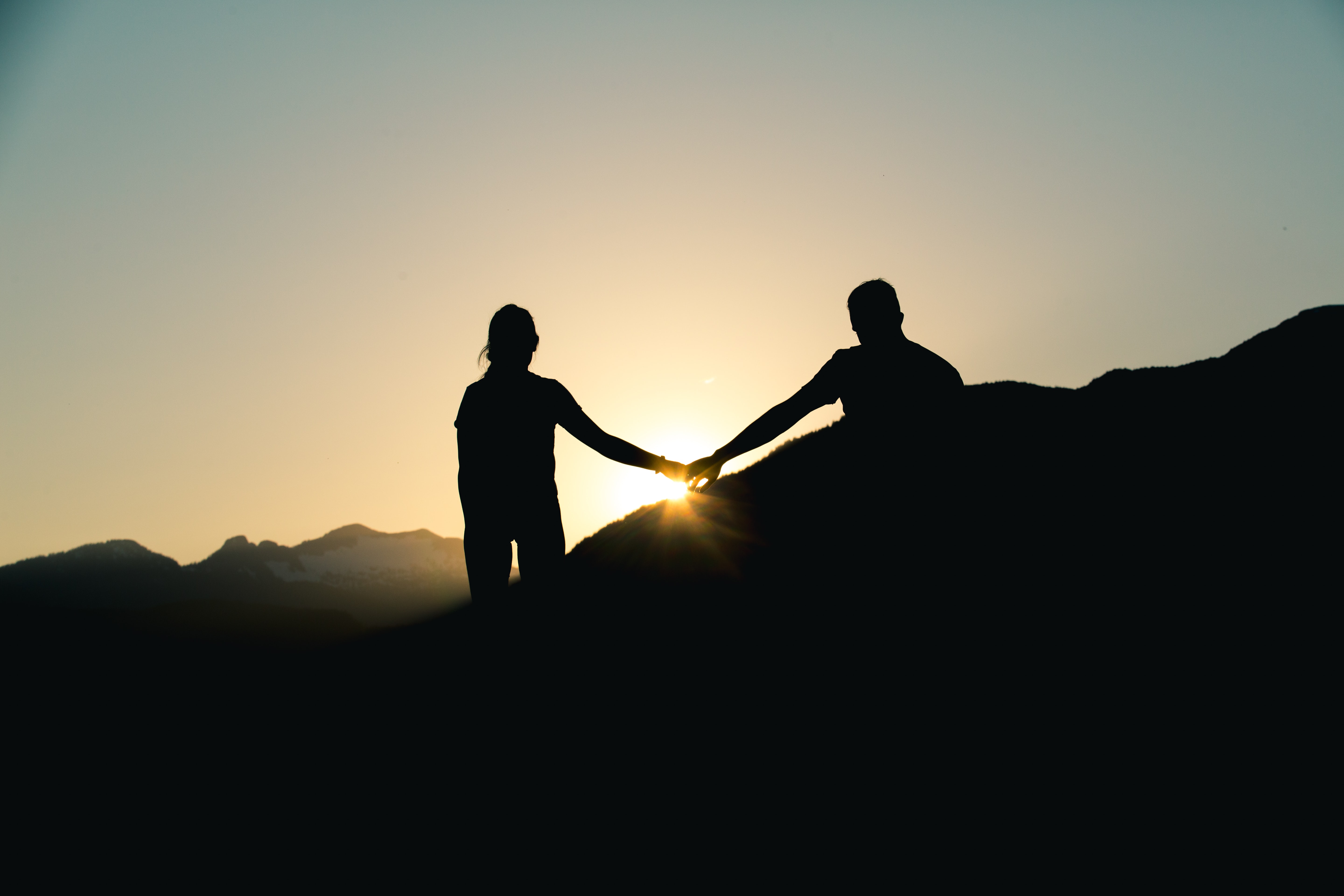 Silhouette of man and woman holding hands