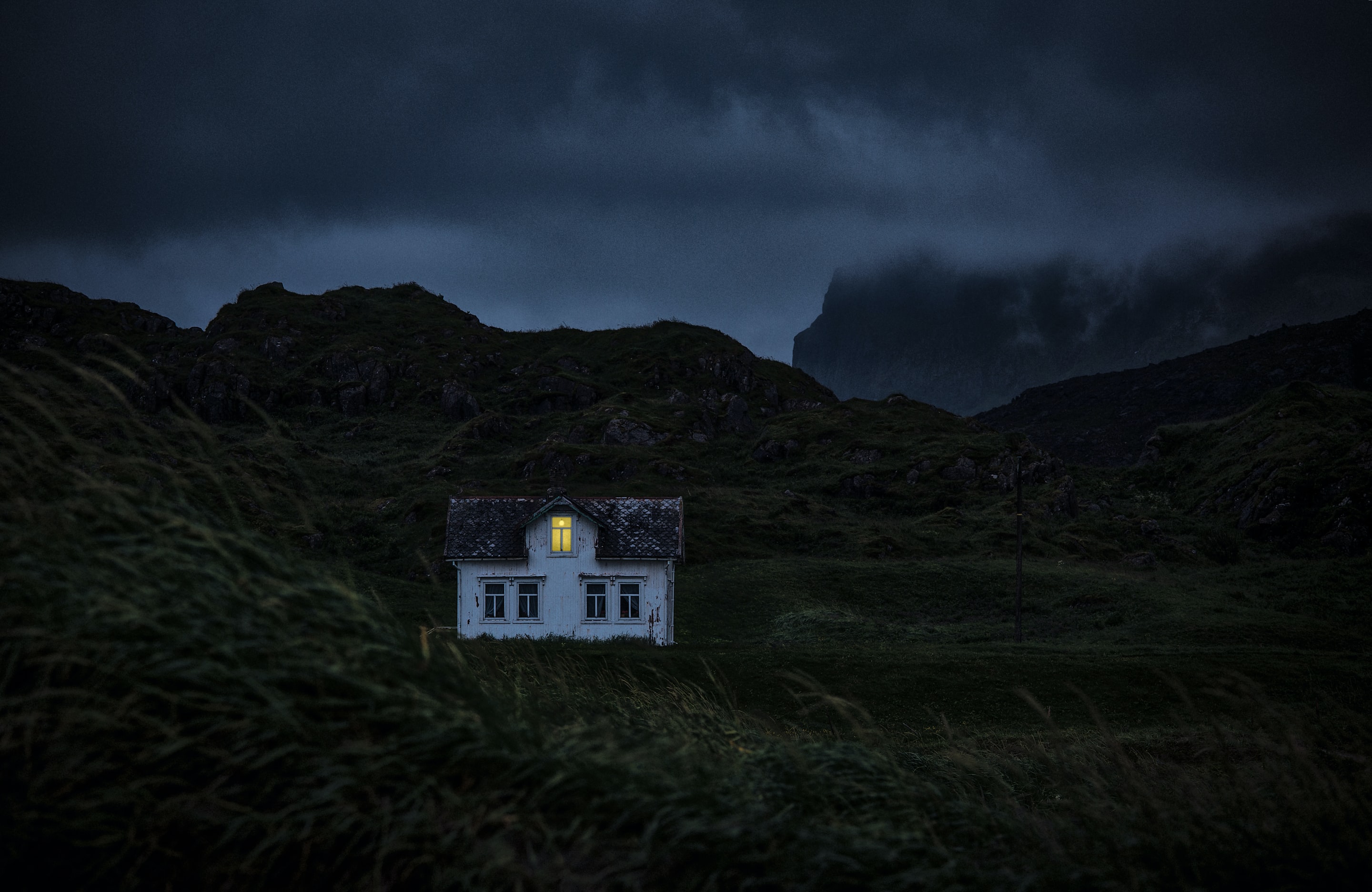 house on mountain under clouds